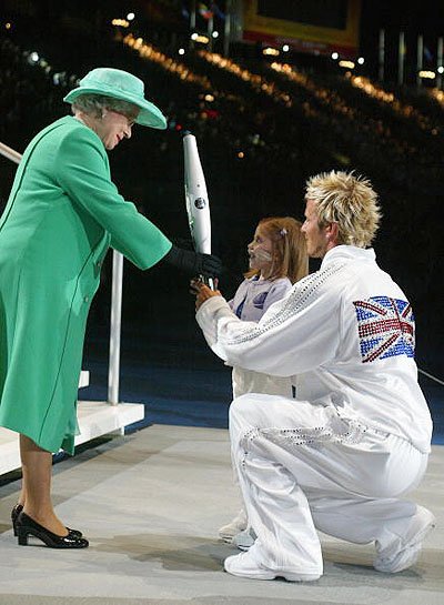 Дэвид Бекхэм вручает факел королеве Елизавете II на Играх Содружества (2002)