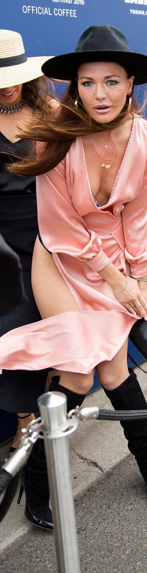The former girlfriend of Lance 'Buddy' Franklin saw the windy conditions blow up her split pink dress. The model looked seemingly horrified as she struggled to contain her free-flowing gown and hide her black underwear