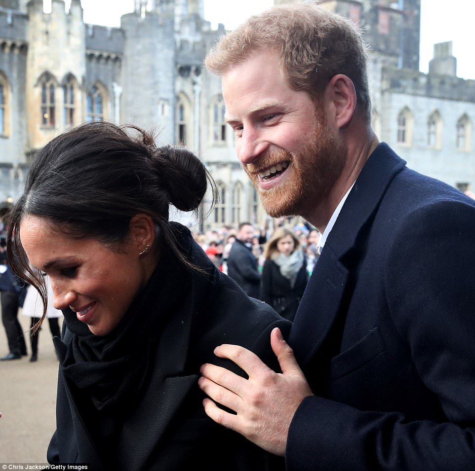 Prince Harry lovingly put his hand on his fiancee's shoulder as he accompanied her around the crowds