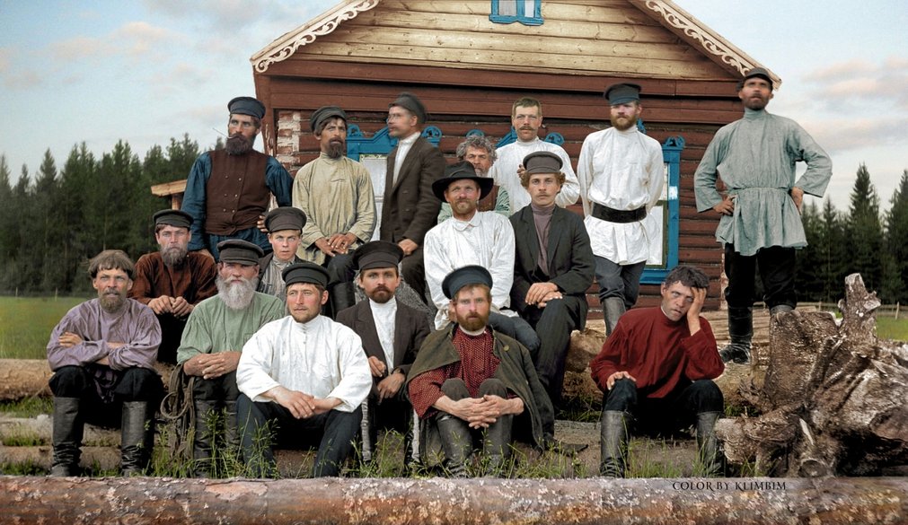 Group-of-peasant-men-pose-in-three-rows-on-logs-in-front-of-log-house,-Russia-1900s-color.jpg