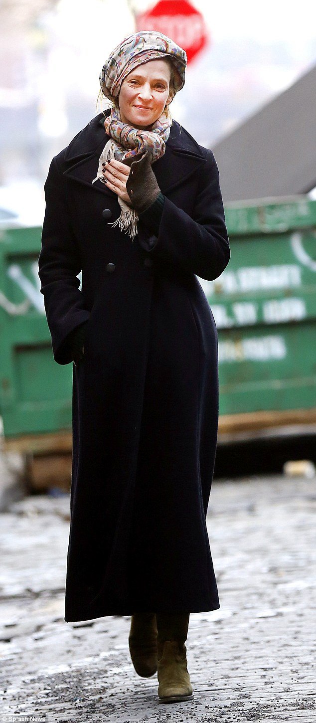 Hitting the city: Uma Thurman wrapped up warm for a New Year's Day stroll in NYC on Friday in a chic coat and pretty printed headscarf