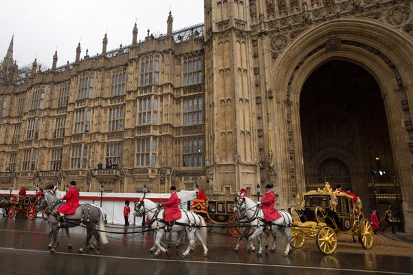 Монарх прибывает в Вестминстер из Букингемского дворца в карете, запряжённой лошадьми, в сопровождении королевской конной гвардии. 