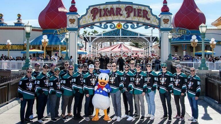 Игроки профессиональной хоккейной команды Anaheim Ducks позируют с Дональдом Даком в тематическом парке Disney California Adventure.