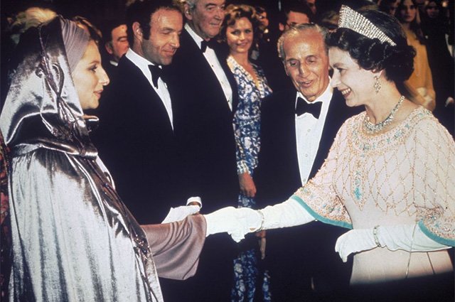 Задолго до Леди Гаги Барбра Стрейзанд доказала, что даже на встречу с королевой может надеть, что пожелает. В 1975 году королеву она приветствовала в лавандовом платье и блестящей накидке в капюшоном
