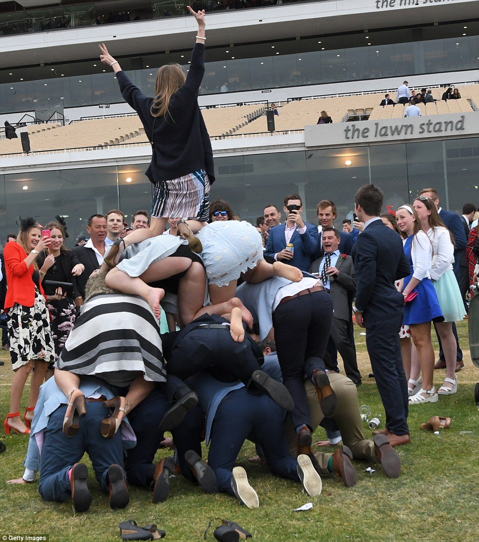 One woman's dress was lifted up at the back during a human pyramid on the public lawn following the last race on Stakes Day