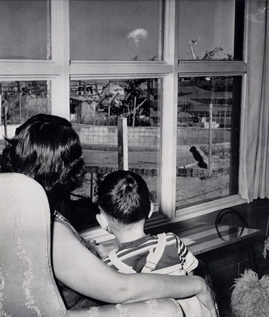 Мать и сын наблюдают за ядерным грибом, видным из их окна во время первых испытаний бомбы. 1953 год