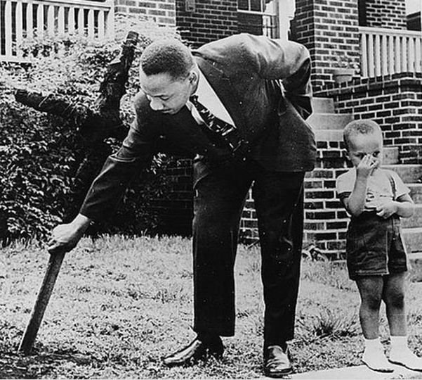Мартин Лютер Кинг и его сын убирают сожженный крест со своего двора. 1960 год