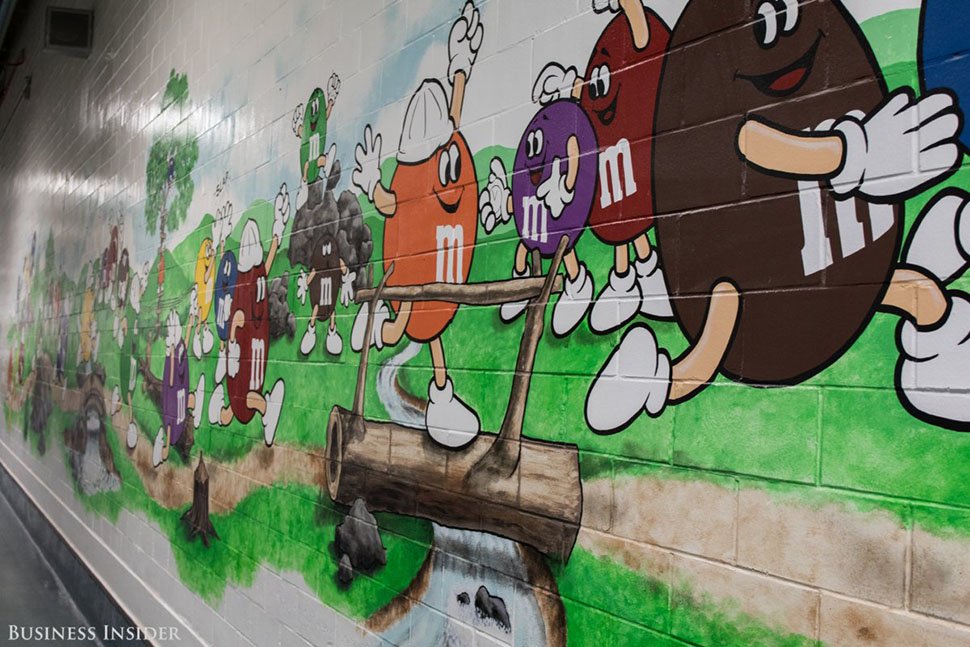 Тур по фабрике начинается с коридора, украшенного яркими рисунками персонажей M&M's.