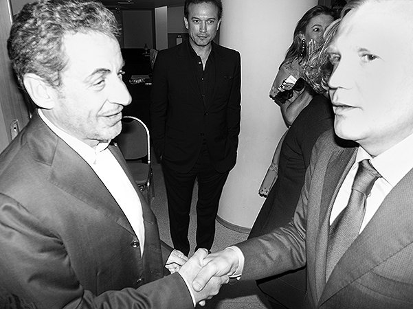 Николя Саркози пожимает руку Дмитрию Шумкову, а на заднем плане актер Венсен Перес